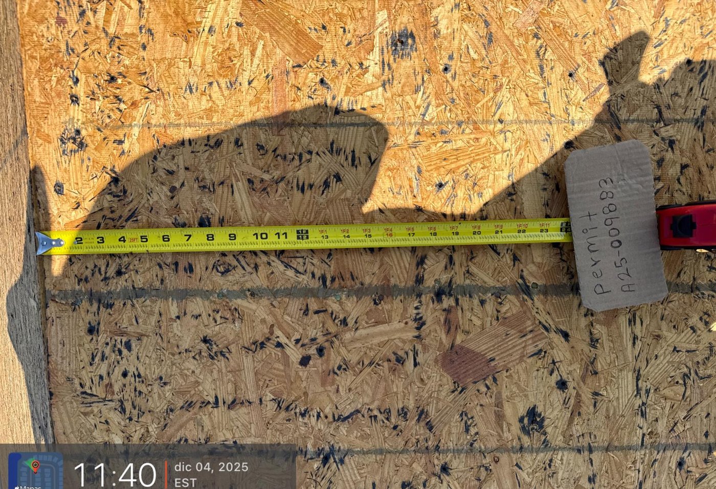 Roof decking inspection with tape measure verifying proper nailing pattern