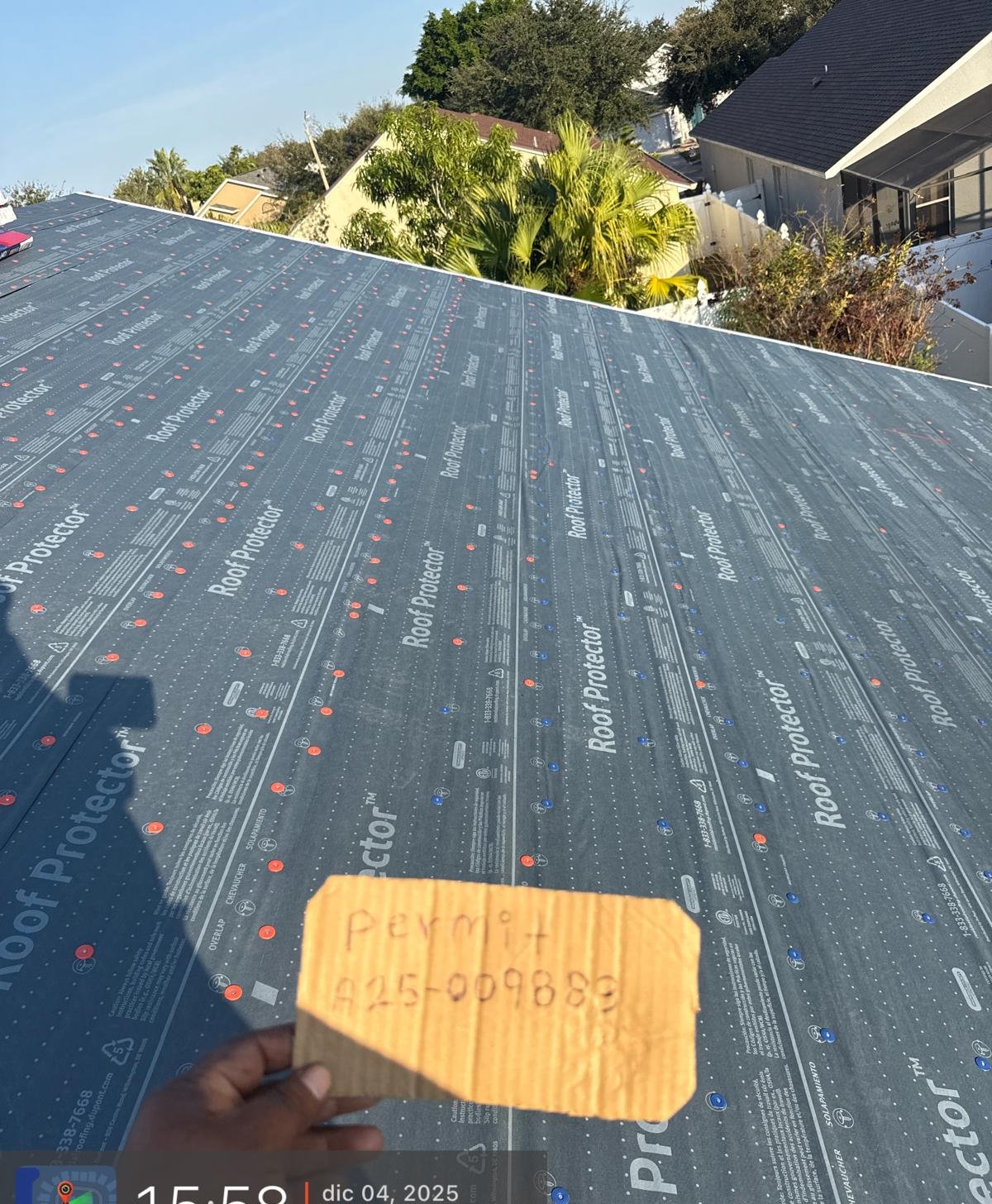 Crew progress on a synthetic underlayment install across a large slope